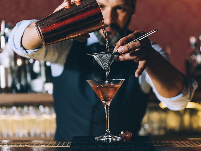 Barkeeper bereitet einen Martini zu